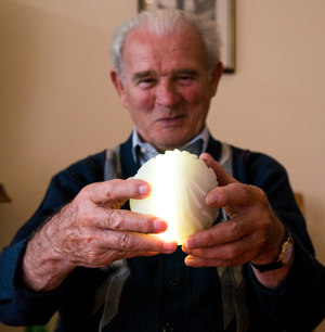 An elderly man holds an illuminated Ichó ball.